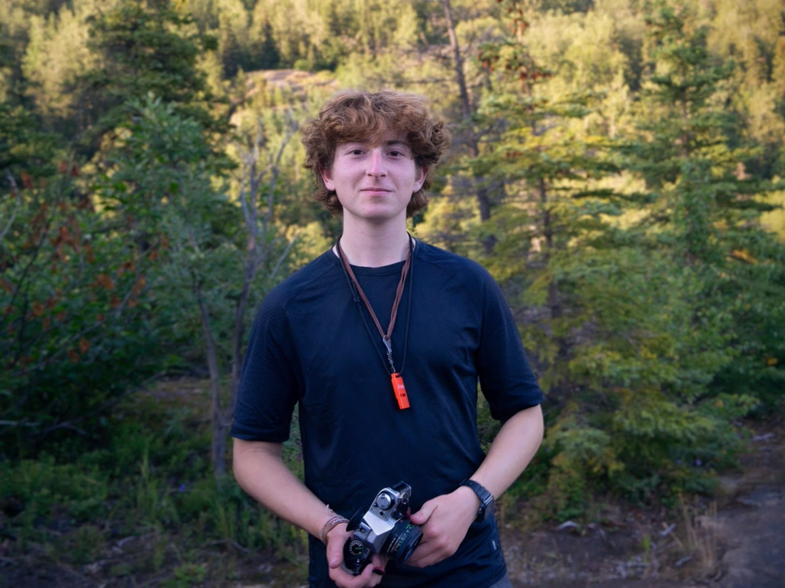 Jack Cappo holding a camera outdoors