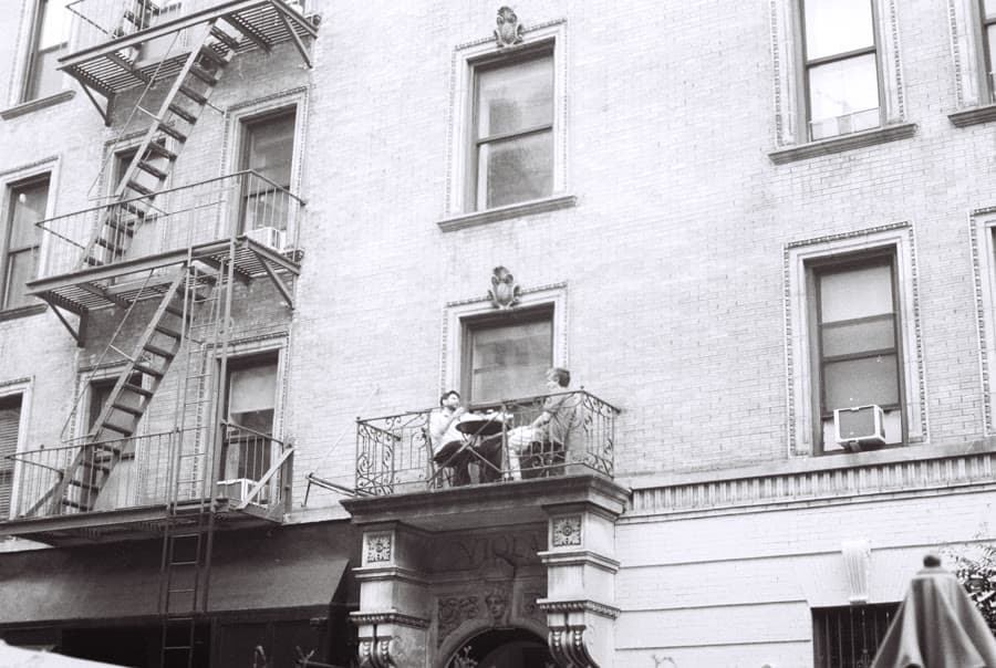 Black-and-white photo of people on a fire-escape balcony